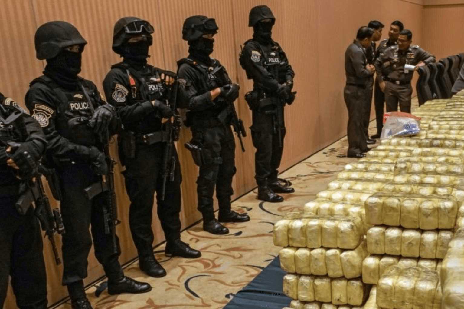 policemen guarding a load of synthetic drugs with a group of officers deliberating the next move