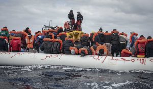 coastal guards saved a group of Libya refugees with life jackets on boat