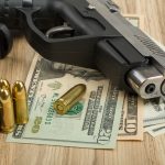 gun, ammunition, money notes laid on table