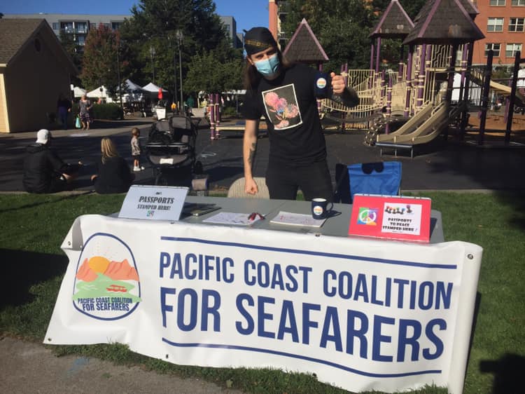 American man standing behind the booth of Pacific Coast Coalition for Seafarers