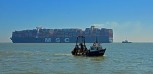 Large Container ship leaving the Orwell estuary Small Fishing Boat entering the estuary at Felixstowe.