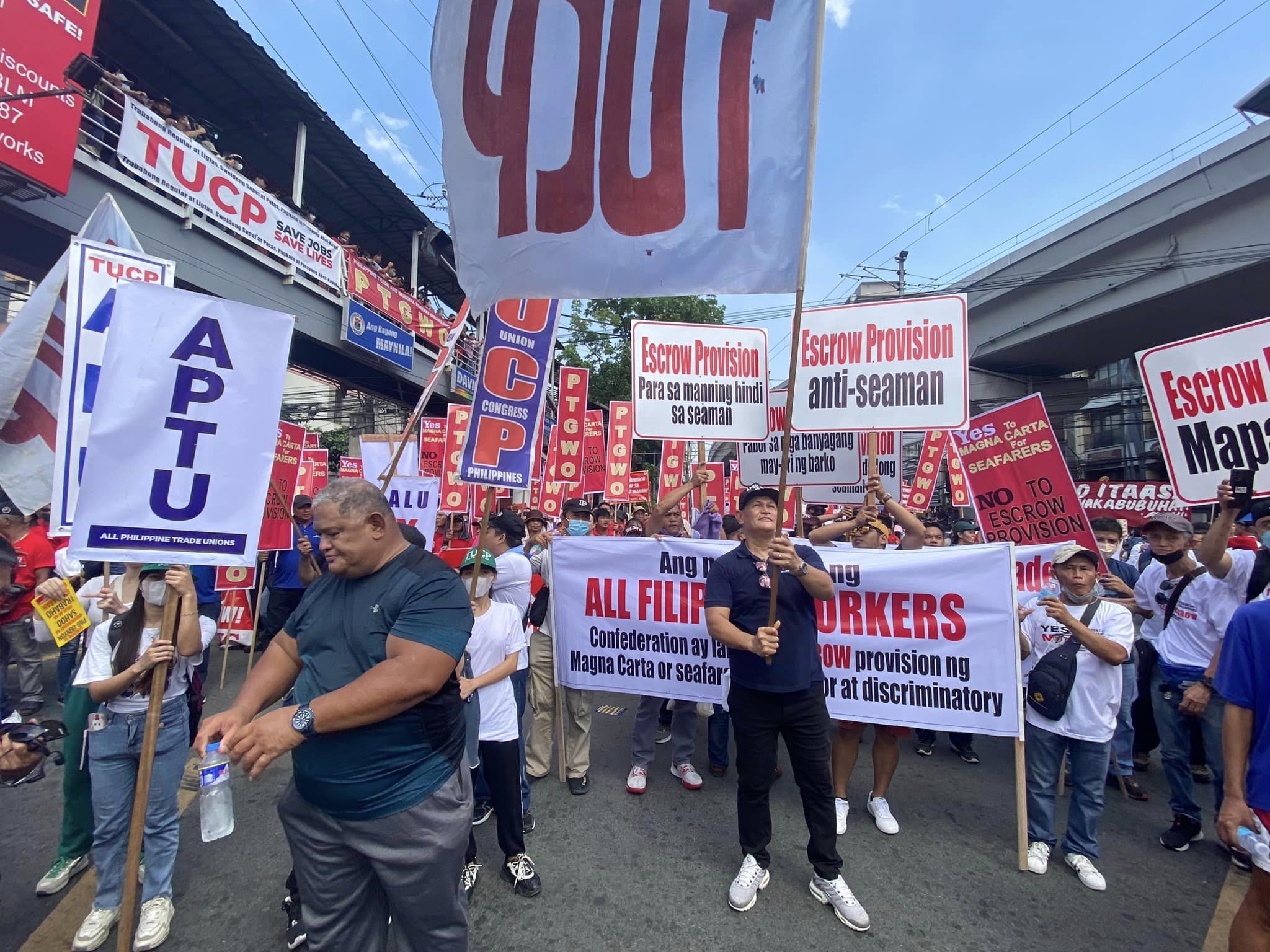 Protestors in Philippines marching on the street with banners "Escrow Provision Anti-Seaman"