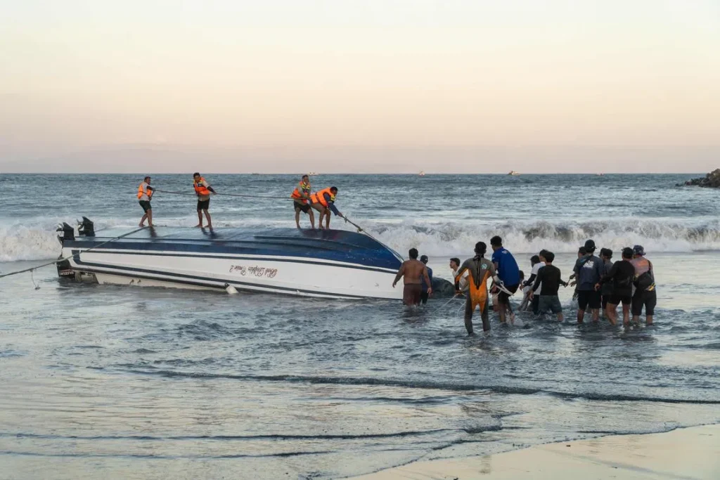 Locals and rescue workers attempt to recover an overturned speedboat after it sank near Sanur port in Bali on Aug 5.