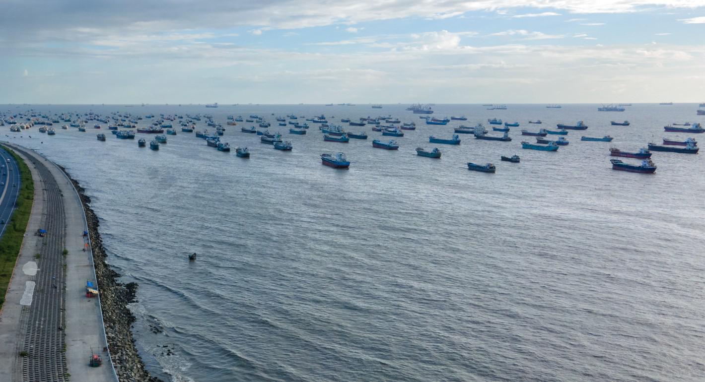 Photo of Donald Trump and Elon Musk standing in front of the White House, facing the camera, with a red Tesla behind them.